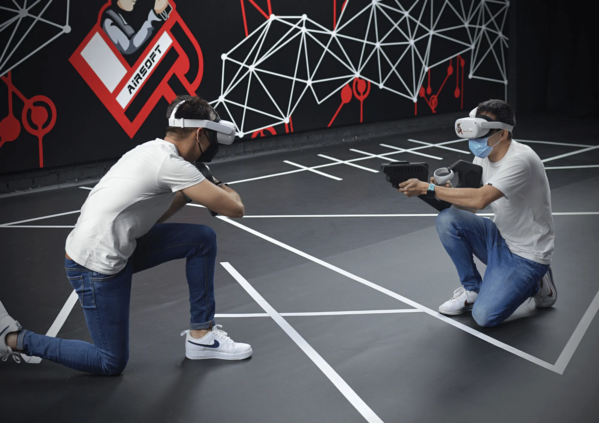 VR Airsoft, chicos jugando a realidad virtual agachados
